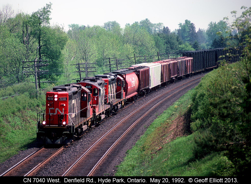 CN 7070 leads a trio of rebuilt GP9's around the curve at Denfield Road back in 1992.  Doesn't seem like much of a grade here but westbound trains had to pull up out of the Thames Valley and believe me, those GP9's are working hard as they lead this London to Sarnia transfer!!