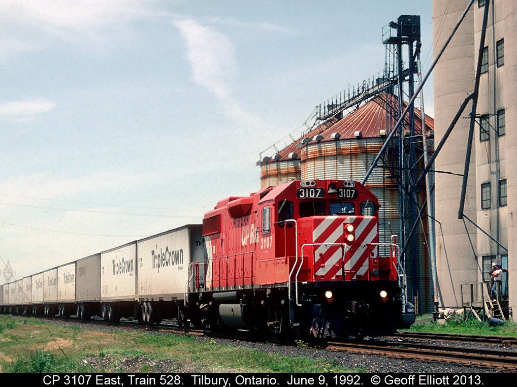 CP 3107 leads Roadrailer train #528 past the old St. Clair Grain in Tilbury, Ontario as 2 workers look on.
