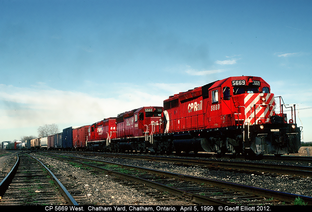 CP 5669, with 3 shades of red SD40-2's, leads a westbound through the east end of Chatham Yard after just having crossed the Thames River (in the background) on it's way to Windsor.