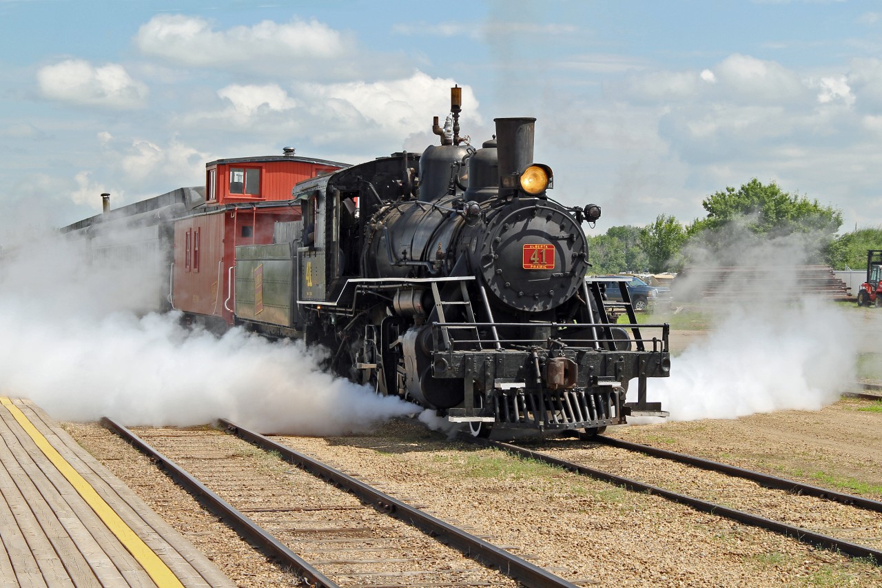 1920 built Baldwin 2-8-0 /41 blows off a good head of steam as it prepares to bring the train into the station.