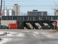 <b>"Locomotive in Traffic"</b><br><br>Suburban Brampton drivers on Steeles Avenue get momentarily distracted as CN 4141 rumbles by the busy thoroughfare with local 578. After finishing switching the industries in the Torbram/Queen/Steeles/Airport Rd. area, 578 is heading back to the mainline to tie onto their train on a sunny winter's afternoon. Extreme telephoto shot taken from near the Bramalea GO Station bus loop area (note the "hills" in the road), making for an interesting perspective.