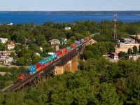 Arguably the best angle in all of Parry Sound, one can view the entire town and miles surrounding from atop the old fire tower, now observation tower. Growing up seeing photographs of Canadian Pacific passenger and freight trains crossing this magnificent bridge in various Canadian railroading books I have always wanted to capture a photo of my own from this location. Although Canadian Pacific no longer runs the trains similar to those captured in Greg McDonnell's book 'Stand Fast, Craigellachie!', for instance, and southbound trains no longer run over this bridge (because of a Directional Running agreement), one can still occasionally get lucky if either CN or CP runs a lengthy train requiring DPU assistance. This is exactly what occurred in this photo, on a crisp July morning, a huge difference compared to the hot and hazy weather days prior. CN Q103 is seen soaring high above town on the Seguin River Trestle with a hotshot stack train for the west coast, leading the train nearly a mile away is CN 8896, in the middle of the train is 2114 and doing the honours on the rear is IC 2698. This train would have a straight shot to St. Cloud over the DRZ section of track in central/northern Ontario.