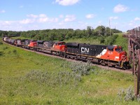 A CN manifest with four units. one being a GMD1, passes through Grant's Cut just east of Rivers.