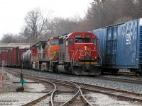 Back in the heyday of foreign power on CN, it seemed like there was something new everyday. If it wasn't a GCFX/WC leaser or an IC SD40, it was something from BNSF, UP, NS or even CSX running though behind CN power. It was often enough that railfans didn't bother staying out for the next train with a trailing UP SD70M or BNSF GE. <br><br> Typical for any interesting lashup, an overcast sky evens the lighting for CN #393, after meeting #392's headend (which had an NS GE trailing) at Georgetown Station, passing the lead into the GO commuter compound in the foreground. CN SD40-2 5365 leads BNSF "Pumpkin" Dash-9 4079 and BNSF GP60M 151, which was still in the warbonnet colours of original owner Santa Fe. This was the best shot of a tight situation, as stopped #392 obscured any shot from the station side, and a typical GO fence fudged any chance of a wider shot of this train and the power seconds later. <br><br> Reportedly ol' 151 had some engine trouble later that day and I believe they sent it back to Mac Yard on another freight. 4079 made another appearance a few days later on a CN #X392 with a BNSF SD40-2 snoot and IC SD40-2. FPON everywhere.