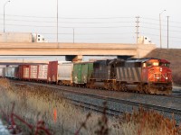 Rolling west into the sunset with a long freight in tow, CN #395 has just passed through the junction of the Halton and Weston Subs ("Halwest") and rumbles through Bramalea GO on the banked curve around the platform. CN SD60F 5520 and IC SD70 1005 lead the charge west to Georgetown, Milton, Burlington, and beyond.