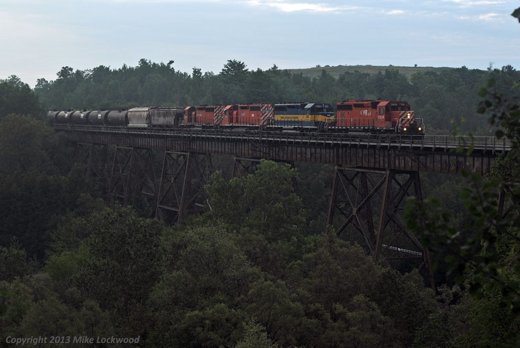 What started as a pretty sunny day has would up dark and drizzly for the last shot of the day. In the gloom,  CP 5926 leads ICE 6416, DME 6087, and CP5972 out onto the Cherrywood Trestle at the east end of the siding of the same name. Thanks again for the heads up, Delic. 2034hrs.