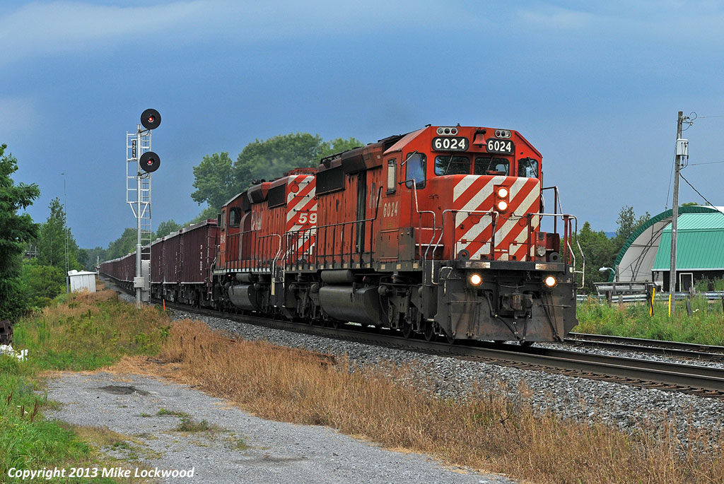 Moving fast under a threatening sky, CP 6024 East, running as GPS2, hit the west end of Colbourne siding. One of the units, CP 5945 is trailing, was having turbo troubles and was loosing power, however it came back to life around Port Hope and they made good time east for a meet with 119 at Brighton, only to act up again east of Trenton. With the number of SD40-2's dwindling, I expect the offending unit may not get repaired and find itself TUSV/TUUS. 1710hrs.