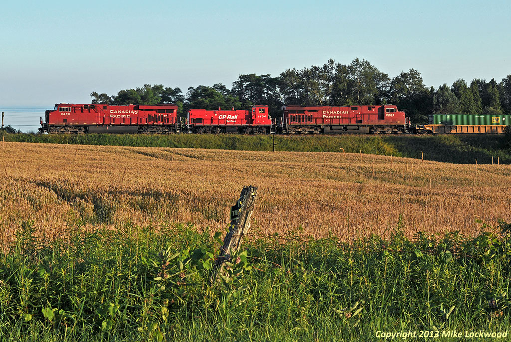 CP 9350, 1404, and 8854 roll 240's train east at Lovekin between a field of grain and Lake Ontario. Stacks capped, 1404 isn't do any of the work as it heads to St Luc for storage. One wonders if in 1975 when she was built as MILW 468, anyone could have imagined shed end up as a CP unit being hauled dead to Montreal between a pair of Gevo's. Probably not. 1959hrs.