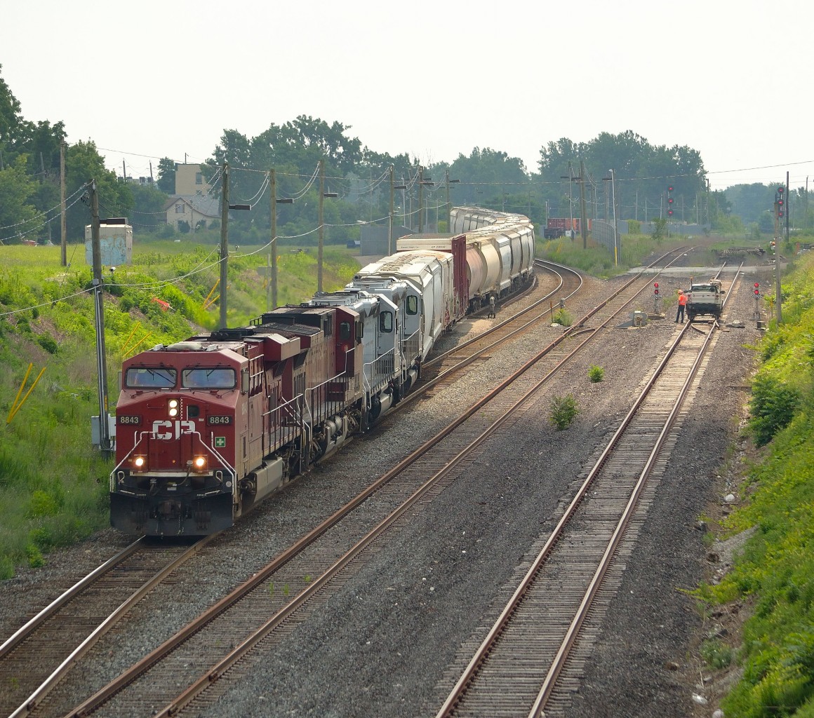 After lifting a pair of CITX and CEFX leasers from Walkerville Yard, CP 243 heads down the grade towards the tunnel to Detroit while a foreman looks on.