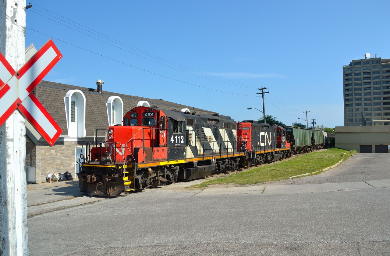 CN 4112 & 7058 paired up are seen pushing a cut of hopper cars back down the CN Point Edward Spur along the Sarnia waterfront.