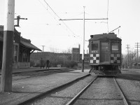 An end view of Grand River Railway electric passenger car 864, sitting outside the GRR - LE&N Galt Main Street Station (not to be confused with the CPR's own Galt Station to the north). The Galt Main Street Station was mile zero for both the LE&N and the GRR. The photo is looking north, 864 is facing north on the southbound track, and the light angle would make this a late morning photo. The car is likely off a LE&N Train north from Port Dover, train #5 to Kitchener.   <br><br> In the background is the McDougall Foundry, a long-gone casting firm. CN's Fergus sub is barely visible to the right of the photo. <br><br> Photo taken by Cecil Hommerding, from the collection (Copyright) of Doug Leffler. Substantial caption information provided by George Roth et al with much thanks. <br><br> <i><u>Other station photos:</u></i><br> The GRR - LE&N Station itself: <a href=http://www.railpictures.ca/?attachment_id=10502><b>http://www.railpictures.ca/?attachment_id=10502</b></a> <br> A better view of GRR car 864: <a href=http://www.railpictures.ca/?attachment_id=10474><b>http://www.railpictures.ca/?attachment_id=10474</b></a> <br> The fantrip stopping off at Kitchener Station: <a href=http://www.railpictures.ca/?attachment_id=10681><b>http://www.railpictures.ca/?attachment_id=10681</b></a> <br><br> For more details on Cecil, see <a href=http://www.railpictures.ca/?attachment_id=10297><b>here</b></a>.