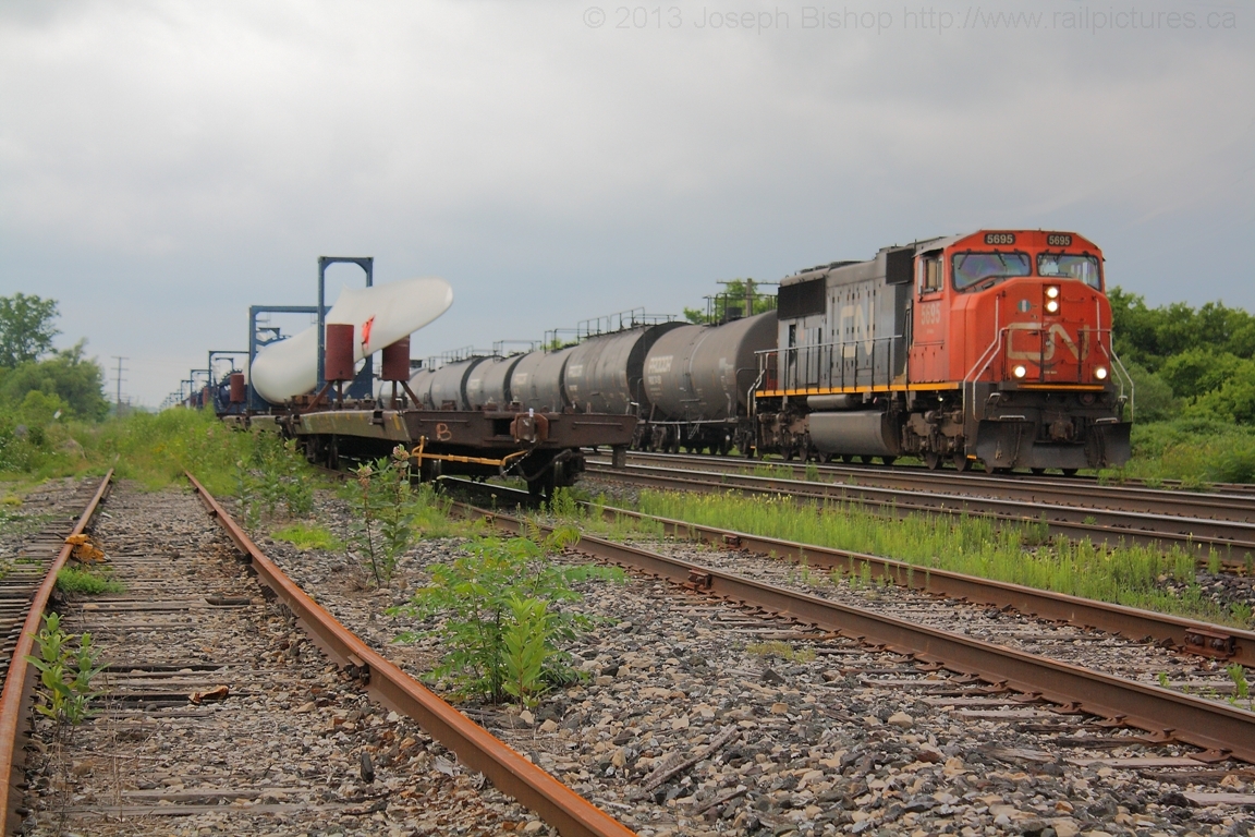 CN L394 rolls through the yard at Paris with 22 tank cars of interchange traffic from the SOR and are heading to  CN Mac Yard in Toronto.  Just a few minutes earlier L394 dropped the windmill blades on the left of the image off for the SOR to lift either tonight or tomorrow