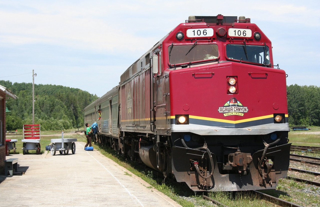 CN F40PH 106 in the handsome new Agawa Canyon Tour Train livery heads CN train 632, the regular thrice-weekly passenger train from Hearst to Sault Ste. Marie. Running over an hour late into Hawk Junction, the train stops briefly to load a trio of canoers and their gear before continuing south.
