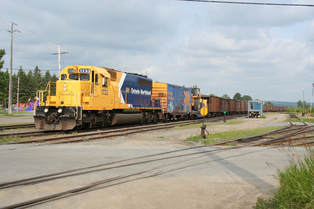 Ontario Northland SD40-2 1733 in the railway's newest paint scheme heads south out of Englehart with a ballast train.