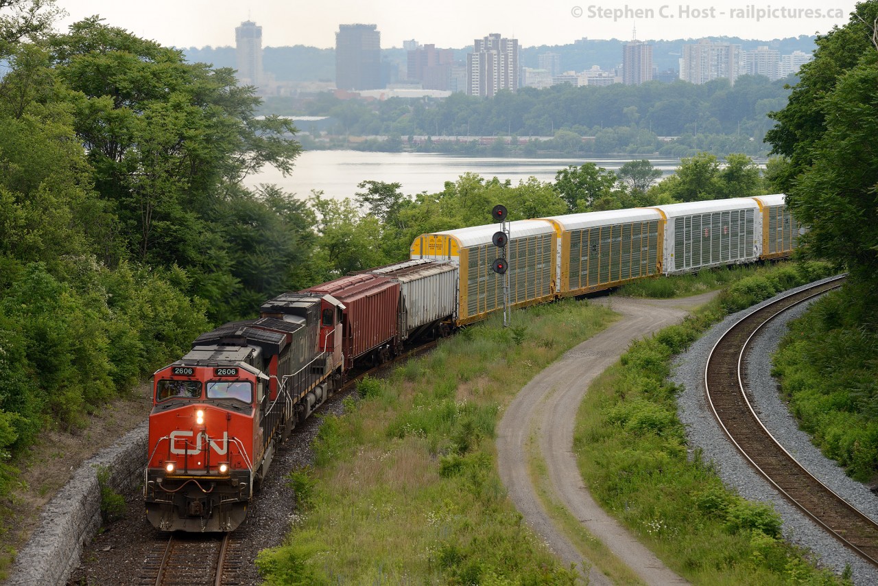 CN M331 is heading up the Cowpath to the delight of a few railfans on the Bridge at the annual Bayview Meet. In the background is Hamilton, Ontario downtown.