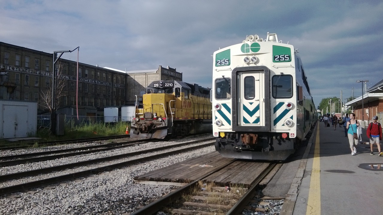 A GEXR locomotive 2210 leased from LLPX sits beside GO Transit Trainset 255 arriving with commuters from Toronto's Union Station a few minutes early at 18:22 on a summer evening.