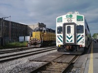 A GEXR locomotive 2210 leased from LLPX sits beside GO Transit Trainset 255 arriving with commuters from Toronto's Union Station a few minutes early at 18:22 on a summer evening. 