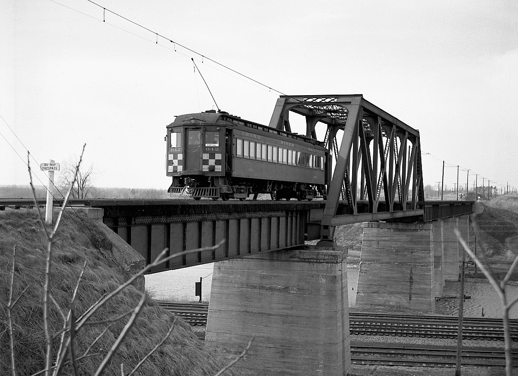 Grand River Railway car 842 heads north over the bridge at Waterford, likely a "posed" shot for the riders on the fantrip it was operating on. It's seen crossing on the Lake Erie & Northern Railway line over the New York Central's Canada Southern (CASO) mainlines and TH&B interchange trackage.While the Lake Erie & Northern Railway ceased passenger service in 1955, freight service continued until the track on this bridge was abandoned in 1981. The track was re-laid over this bridge in 1984 for the CPR/Stelco Steel Train, only to be abandoned again a few years later. This bridge is still located here and it has been acquired from CP to be part of the rails to trail project call “The Waterford Heritage Trail” that uses portions of the TH&B and the LE&N right of way as a paved trail for cyclists and others through the area today.  Car 842 was the car used in the above described fan trip organized by several Michigan area railfans.  Photo taken by Cecil Hommerding, from the collection (Copyright) of Doug Leffler. Substantial caption information provided by George Roth et al with much thanks.  More views from the fantrip: Stopping at Kitchener: http://www.railpictures.ca/?attachment_id=10681 Stopping at Paris: http://www.railpictures.ca/?attachment_id=10356 Visiting the GRR/LE&N Galt Station: http://www.railpictures.ca/?attachment_id=10502  For more details on Cecil, see here.