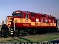 Wisconsin Central "Heritage" unit, GP40-2 #3027, sits in downtown Sault Ste. Marie, Ontario as the power for the passenger train.  It was rather odd as this consist came in the night before and had not yet been turned to go back north today.  Thought it was appropriate that the Canadian Flag hangs above the unit which displays the flags of Ontario, Michigan, Wisconsin, Illinois, and Minnesota.