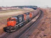 Two of Montreal's  finest: MLW Century 630M's coast downgrade - about to pass under the Stephenson Road / Lakeshore Road bridge CN Kingston mile 284.3....that curve was more super-elevated prior to the LRC's introduction !<br><br>To commemorate the 2013 CARM Convention ( August 9 to 11 ) in Port Hope please enjoy this April 1980 Kodachrome of a westbound (and now relatively rare) conventional CN freight – in two paint schemes - on the approach to the Clarke crossovers. <br><br>CN Century's 2036 and 2026, built 1967-8, and sisters were all gone by 1996, with nine sold to CB&CNSRy.<br><br>That is the CP Rail  Lovekin siding – Belleville Sub mile 156.0 - in the left background and note how the land between was once farmed – a real challenge today to a get a clear shot of a westbound CPR !<br><br>April 1980 Kodachrome by S.Danko<br><br>More Stephenson Road bridge area action:<br><br><a href="http://www.railpictures.ca/?attachment_id=8700">  two CP Toasters  9840 – 8919 </a> <br><br><a href="http://www.railpictures.ca/?attachment_id=1849">  Via CN train #63 the Rapido  </a> <br><br><a href="http://www.railpictures.ca/?attachment_id=9108">  THE BRIDGE! </a> <br><br><a href="http://www.railpictures.ca/?attachment_id=3101">  THE BRIDGE - repaired! </a> <br><br><a href="http://www.railpictures.ca/?attachment_id=1568">  CN Newtonville </a> 