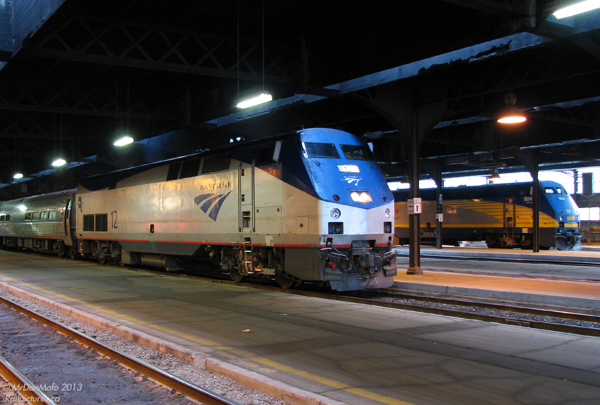 Sitting under the train shed before departure an hour later, Amtrak P42 12 and its train of Amcans (nickname for the round-side Amfleet passenger cars) waits at Toronto's Union Station on VIA #97 "The Maple Leaf". Operating with Amtrak equipment but using VIA crews in Canada, it will depart at 8:30am for Niagara Falls, and after customs inspection will cross the border into New York as Amtrak #64 with an American crew from Amtrak.

Lurking a few tracks down, VIA 904, another General Electric P42, waits with a ho-hum corridor train alongside it's foreign kin.