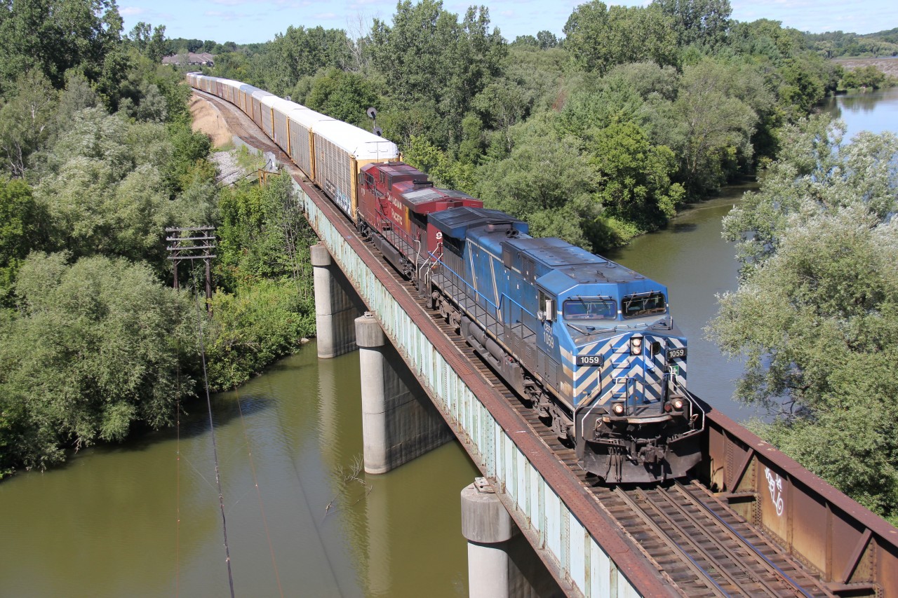 CP 147 with a bluebird in the lead heads west under blue skies.