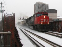 It was a cold winter morning in Southern Ontario when a Denver & Rio Grande Western tunnel motor (albeit patched, but still in full D&RGW colours) was due to head back out on a freight, which had came in on an eastbound the previous night at CN's MacMillan Yard. Having arrived at the station dark and early in the morning (06:30 hrs) in hopes of catching it before my morning train to Toronto, it became a waiting game as various CN freights juggled track time with the 4 morning GO trains and VIA. All the while text messages between people in the know were exchanged, and it was determined it was going to be going out on #391 or possibly #399, but #391 came and went with only a UP SD70M trailing.
<br><br>
At 07:59 a decision had to be made, and the photographer reluctantly stayed on the cold snowy platform as the last GO train to Toronto pulled out of the station without him. Unheated platform waiting shelters are very ineffective in the cold, but there wasn't much choice for one not wanting to stray too far from the tracks - lest his pray show up while he was waiting in the station with no clear line of sight, or up the street buying some warm pizza at Gusto's.
<br><br>
Finally, a headlight poked up on the snowy horizon, and back out into the snow we go. CN #399 with SD75I 5655 and UP "DRGW" SD40T-2 8612 thunder over the steel bridge above Main Street, heading west through downtown Brampton in the falling snow. The trailing unit shot was a touch blurred, but this one turned out okay considering.
<br><br>
The next step? Hop on a GO bus for a one-hour express trip to York Mills and the subway downtown, 3 hours after arriving, but with a DRGW in the camera.