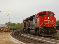 A crew from Brantco Paving works at grading the VIA platform as CN 8846 - CN 8835 lead an eastbound past