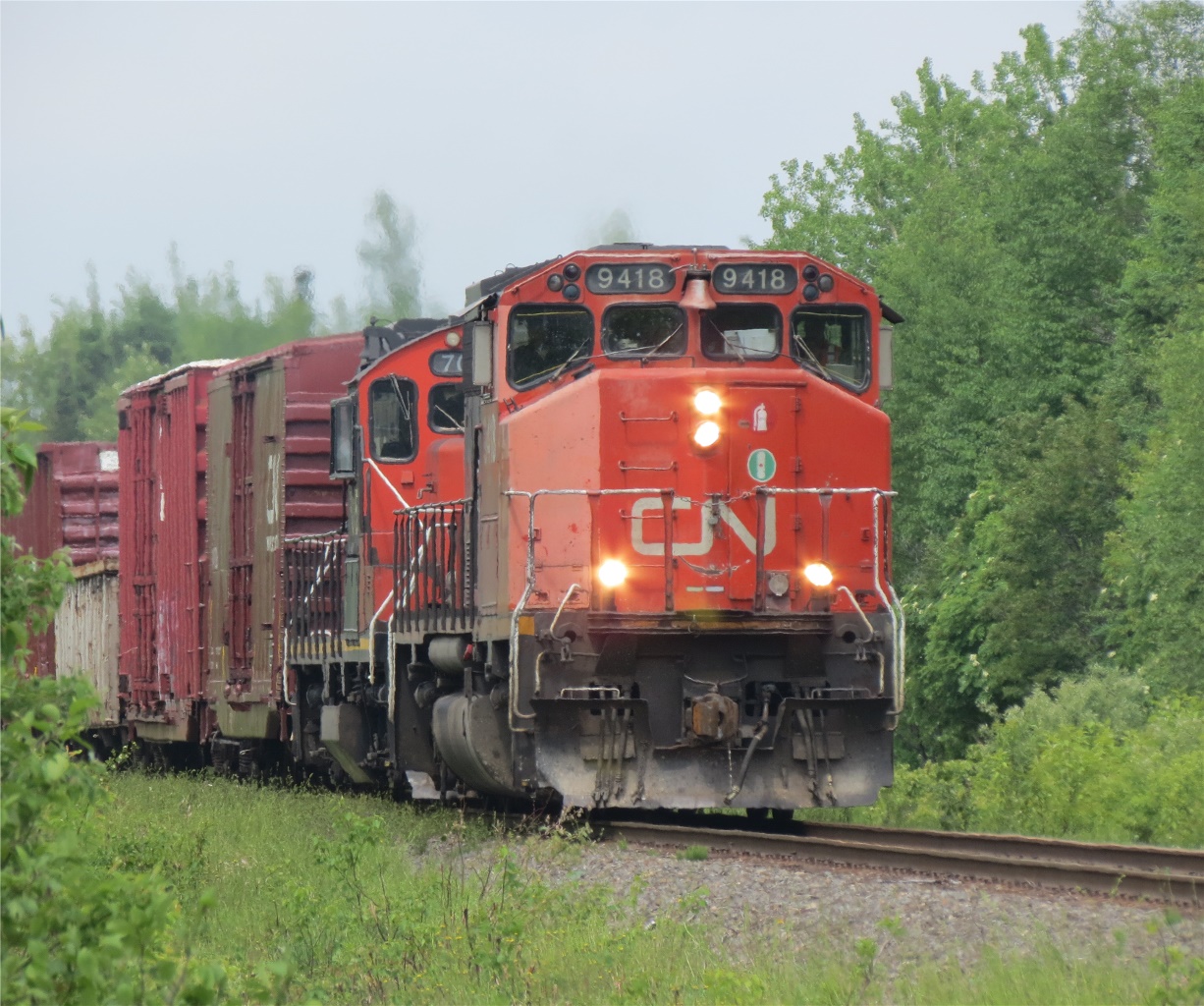 The daily local from Campbellton NB to Bathurst passes the VIA depot at Jacquet River.  CN 9418 and CN 7015 climb out of the river basin and will work up the tracks at Belledune (CHALEUR LUMBER).