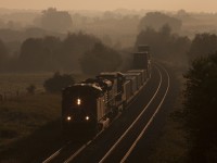 The first day light train rounds the curve, 8921 west Q107 breaks the morning silence as it hustles across the country side.