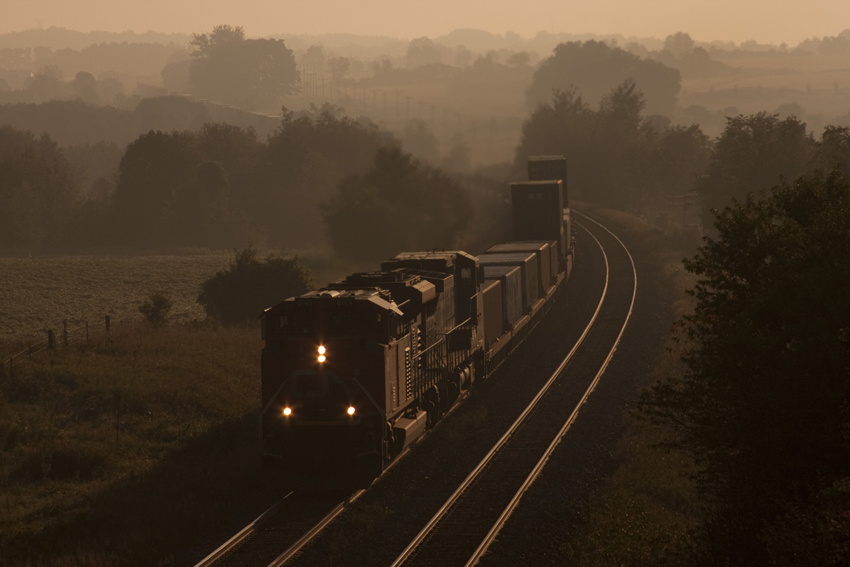 The first day light train rounds the curve, 8921 west Q107 breaks the morning silence as it hustles across the country side.