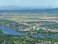 With a very long train, CN 120 pass over the Richelieu river. In the same picture, you can see Montreal downtown, the ''Mont-Royal'', the Olympic stadium of Montreal, a part of ''Mont-Saint-Bruno'' and few cities like Montreal, Saint-Basile-le-Grand, McMasterville, Beloeil, etc. The shot was taken on the top of the ''Mont-Saint-Hilaire'' with an elevation of 415m.