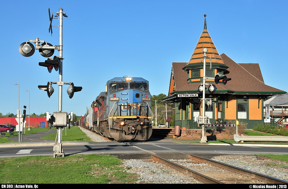 In the sunset, CN 393 pass in front of the old Acton Vale station. The station, built in 1904 by GT, was restored in 1983. In 2010, the station was rehabilitated in the original colors.