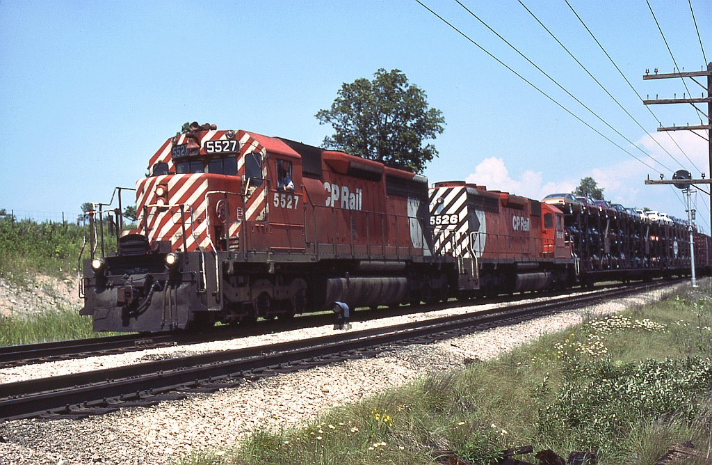 A pair of SD40 sisters, CP 5527 and 5526, pull their train through the east siding switch at Lobo just west out of London.