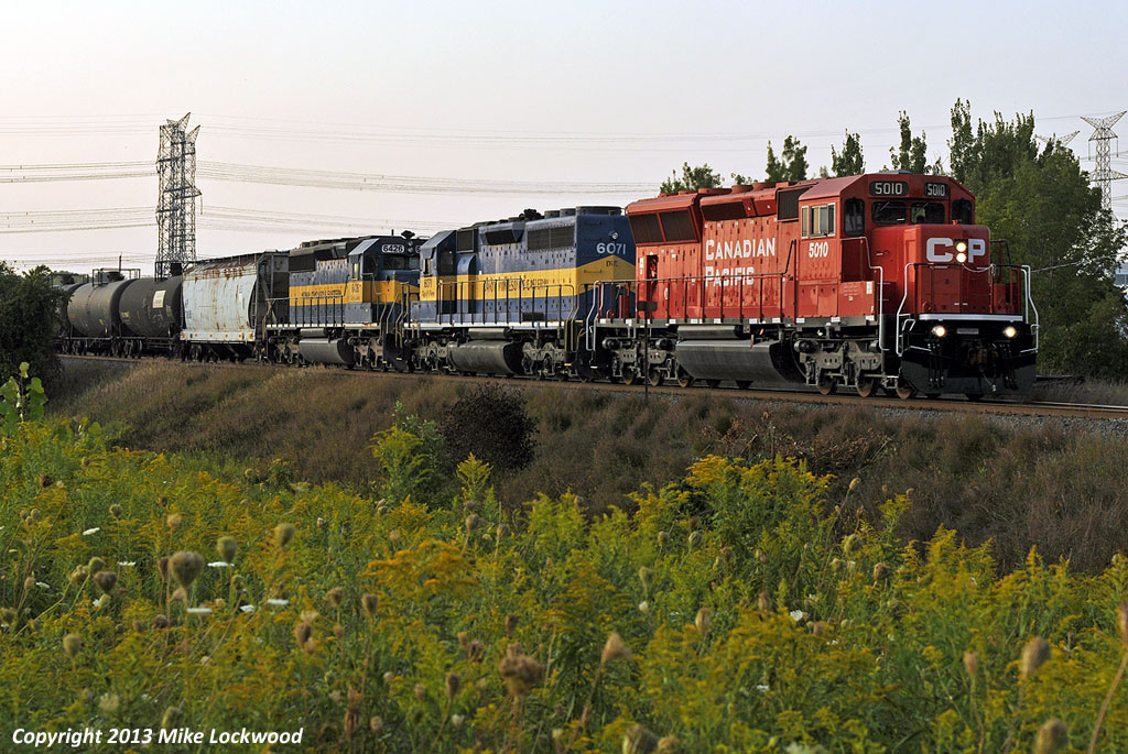 A late in the day eastbound leaves few options in terms on shooting, so a short, south facing straight section of an S-curve in north Ajax had to do (once pruned). The cloud was not part of the plan, but so goes the foam. CP 5010, DME 6071, and ICE 6426 lead 642's train east. The SD30C-ECO will be a most welcome break from those cursed toasters and waffle irons. 1902hrs.