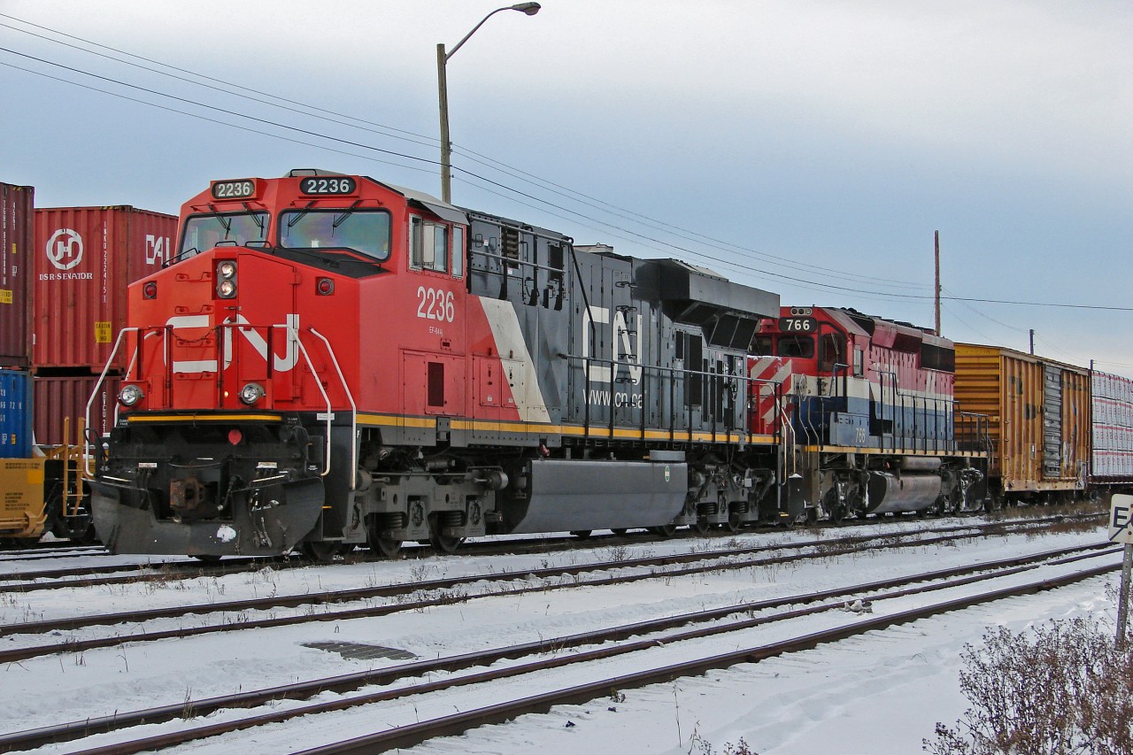 Heading East out of Edmonton, seen between Walker Yard and East Junction, are ES44DC CN 2236 and BCOL SD40-2 766 in "hockey stick" livery