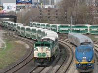 Don't believe your eyes, there's actually 4 trains here. A morning at Bathurst Street bridge finds: <br><br> 1) Part of a GO train in the background using the rarely-used connector track, to get from the Galt Sub/Weston Sub side to the Oakville Sub side in order to head west to GO's Willowbrook maintenance facility in Mimico.<br> 2) VIA 911 with equipment off #90, backing to VIA's Toronto Maintenance Centre from Union Station.<br> 3) GO 560 on a not-in-service train, snaking through the switches onto the main as it heads back to Willowbrook .<br> 4) And GO 561's train, whose unit is nearly invisible because it's coupled to the end of 560's train, leading the trip west. <br><br> For those wondering about the billboard, the Inglis sign's inspirational quote of that day: "Take to heart only / Those things that / Make you stronger"