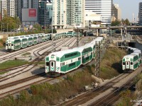 <b>Commuter Chaos.</b> At the height of evening rush hour, GO trains are coming and going every which way out of Union Station. At Bathurst Street, GO cab car 235 leads the first evening Bradford line (not extended to Barrie yet) train, #801, out of downtown Toronto on its way to Parkdale and up the Newmarket Sub. GO 215 leads Lakeshore West train #479 out of the Flyunder, destined for Mississauga, Oakville and Burlington. On the left, Bathurst North Yard is emptying as trains that have laid over the afternoon depart for Union Station, where they will load weary commuters heading home north, west and east of Toronto.