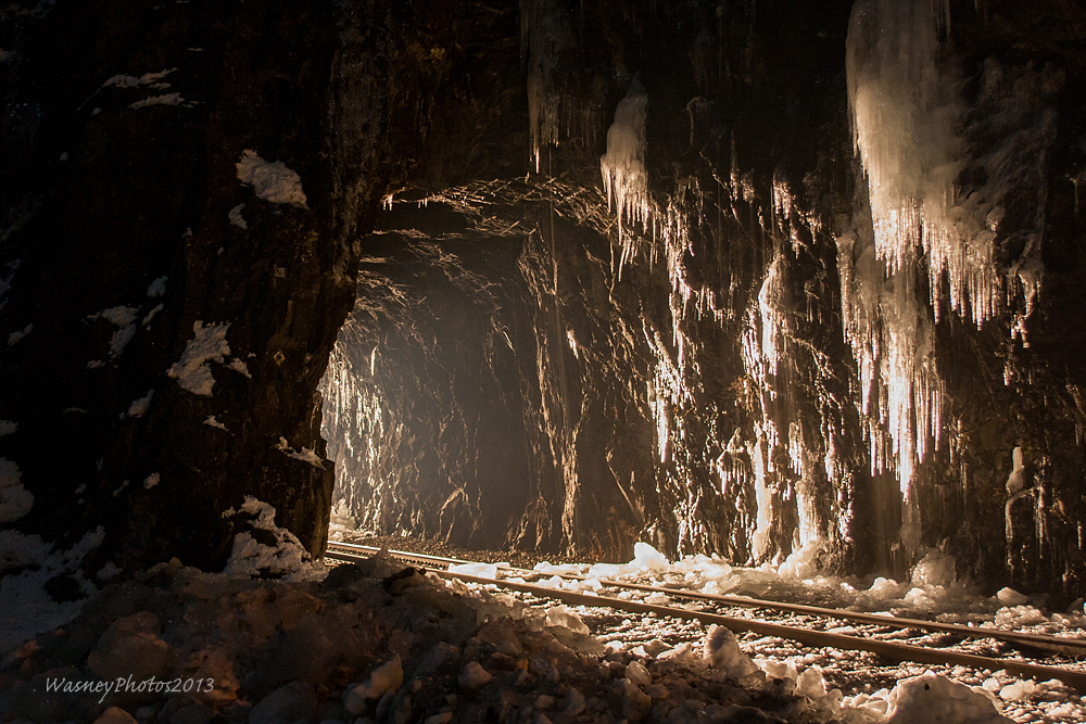 The lights of a CP eastbound glows through the first of three tunnels situated in the historic town of Yale, BC, showing off the icicles that dangle around the tunnels mouth.
