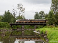 Returning westbound from Mission, BC, CPs heritage train crosses over Kanaka Creek in Maple Ridge BC. Despite the grey weather the winds managed to keep away, allowing for a nice reflection. 