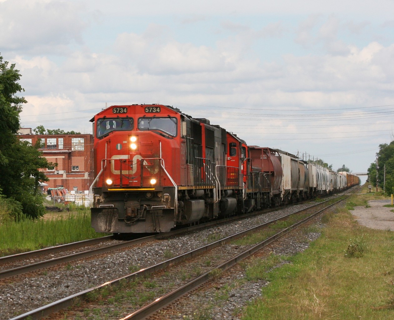 CN A435 is led by 4 locomotives westbound by the Woodstock VIA Station.  5734-5436-7245-231 make up this trains' lashup.