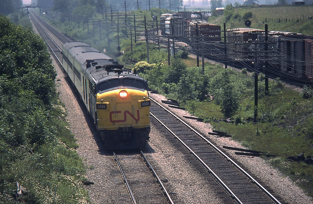 Zipping eastbound with a 4-car passenger train, VIA/CN 6526 approaches Hyde Park on the outskirts of London on CN's Strathroy Subdivision. In the background, a manifest freight can be seen on CP's Windsor Subdivision at Lobo siding.