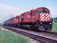 M-636 #4702 leads an M-630 and an RS-18 east on hot container train 502 at Lovekin siding, Belleville sub in August 1990.