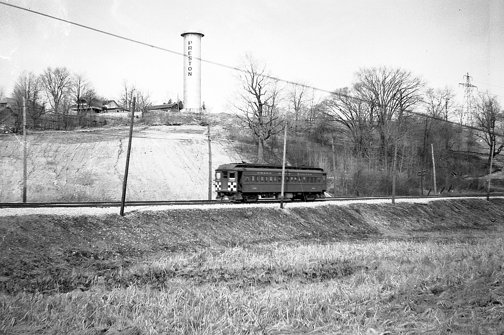 A Grand River Railway passenger motor car is heading north behind the Preston Shops on Kitchener-bound train 5, (seen earlier at Galt Main St Station), passing on double track below a silo bearing the town's name. This is the on the start of the 2.5% grade up to flag stop Hagey, enroute to Kitchener.  Photo taken by Cecil Hommerding, from the collection (Copyright) of Doug Leffler. Substantial caption information provided by George Roth et al with much thanks.  Other photos at Preston: GRR's Preston Station: http://www.railpictures.ca/?attachment_id=10943 Car 864 at Galt Station: http://www.railpictures.ca/?attachment_id=10474 Car 848 at Preston: http://www.railpictures.ca/?attachment_id=10298   For more details on Cecil, see here.