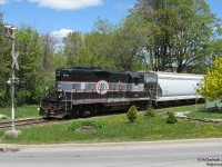 <b>North Side Gal.</b> <br><br>While everyone always chases and photographs the Orangeville Brampton Railway's trip from Orangeville to Streetsville and back, there's another segment of the line less photographed. <br><br> On this day, after making the trip south to Streetsville and back, CCGX 1000 gathered some cars in the yard and left in the opposite direction of her arrival: north, to switch the few customers in the northern Orangeville industrial sector. Here we find the ol' gal, after spotting and lifting some cars, pushing her short train past the landscaped yards of quiet Orangeville neighbourhoods on the trip back to the yard.