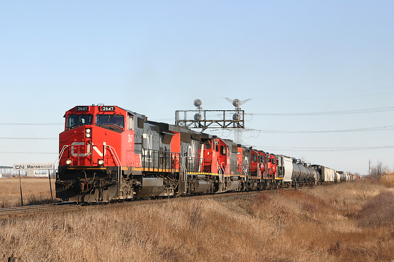 CN 2647 and an assortment of power leads 396 up the grade through Mansewood