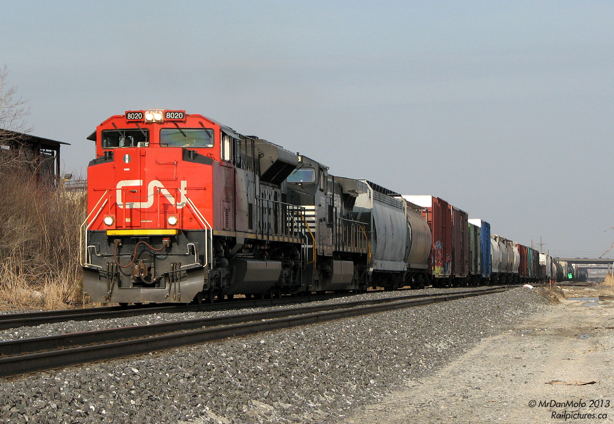 "Quickie"

On the way home from some errand at Shoppers' World otherwise too mundane to be memorable, a probable squawk out of the VX150 telling us CN 399 was approaching necessitated a pit stop behind our favourite deserted big box plaza photo spot off Kennedy Road. At the time the 3rd track of CN's Halton Sub had not been laid, and the area of "old Peel" was nice and wide open for decent train shots (even if the light was straight down the track at this time of day). It almost made the horrible stench from the nearby asphalt shingle plant tolerable.

But anyway: Our short 399, the tail end of which can be seen in the distance under the Highway 410 overpass, is dodging the evening GO trains while making a break for freedom at CN Silver (Georgetown) and beyond. Nearly new at the time CN SD70M-2 8020 is on point, with NS "Catfish" C40-9W 9555 reppin' the FPON content that made "quickies" like this more "I wonder what interesting foreign thing will turn up" rather than today's "I wonder what boring CN thing will be on it", to paraphrase a friend.