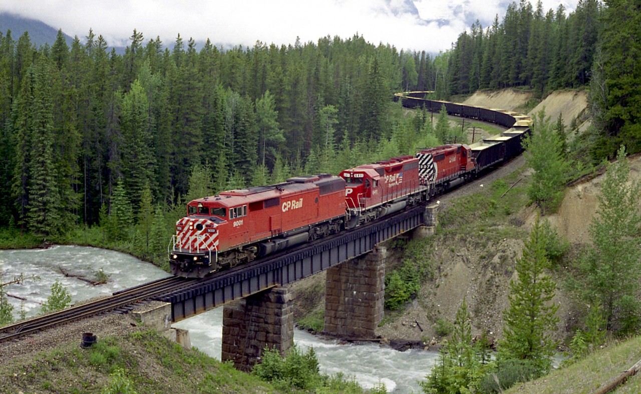 Back when the Red Barns were preferred power! CP 9001 West crosses over the Ottertail River with a long unit sulphur train. Scanned from an old print.