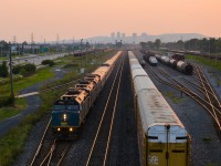 <b>Sunset at Southwark.</b> The combined VIA Rail Ocean/Chaleur is passing through Southwark Yard at sunset, with downtown Montreal's skyline barely visible in the distance. At right is CN 309, stopped to set out some TankTrain cars. This is a very long consist, with three F40's, five ex-CP stainless steel cars (the Chaleur section of the train), about 17 Renaissance cars and an ex-CP Park car bringing up the rear. With the Chaleur being cancelled, this train is shorter at present time. For more train photos, check out http://www.flickr.com/photos/mtlwestrailfan/