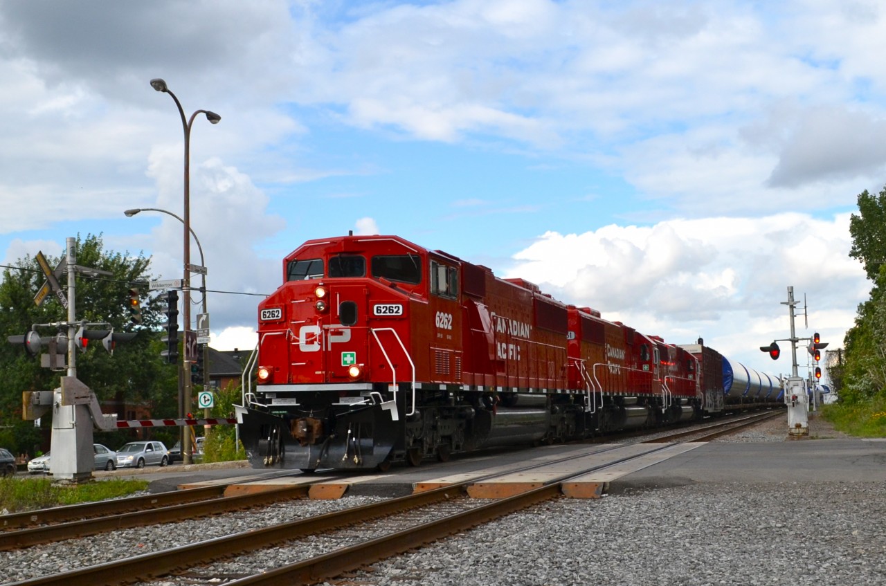 While the tracks and the equipment is CP, this is a Quebec-Gatineau windmill train with a Quebec-Gatineau crew. It is on its way to St-Luc Yard and is crossing Wilderton Avenue. Power is three 'resurrected' ex-SOO units: CP 6262, CP 6251 & CP 6247.